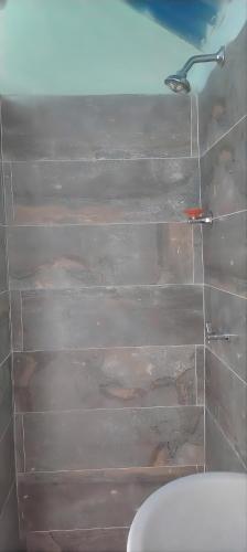 a bathroom with a wall with a shower and a toilet at cabañas de descanso in Anolaima