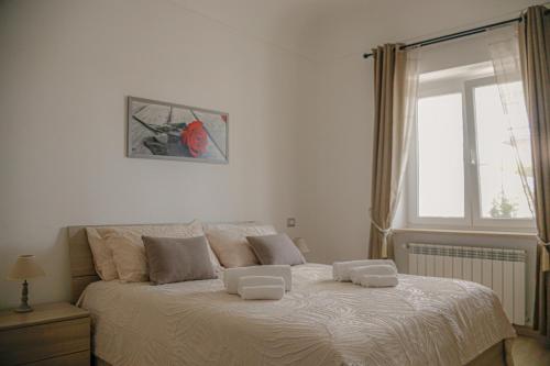 a bedroom with a large white bed with a window at La Primavera in Anacapri