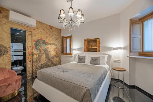 a bedroom with a bed and a chandelier at B&B Rocca del Civitillo in Notaresco