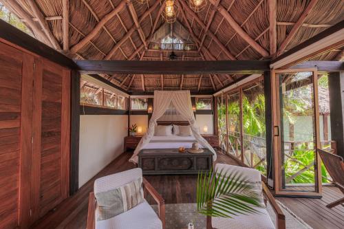 a bedroom in a villa with a bed and chairs at Hotel Boutique Siete Lunas in Sayulita