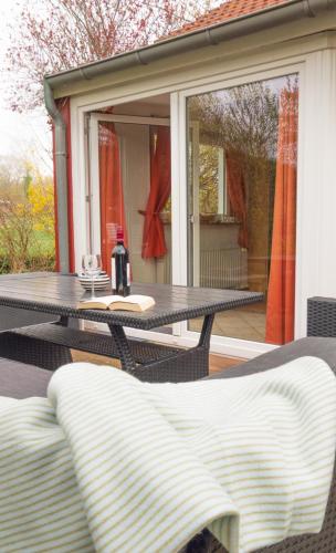 a table and chairs on a screened in porch at Schwedenstern - Familienurlaub an der Ostsee in Kochendorf