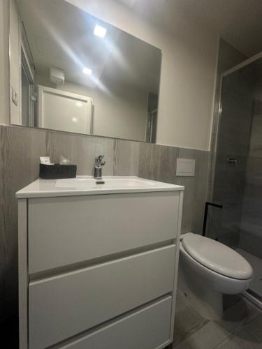 a bathroom with a white sink and a toilet at Il laghetto 19 in Capodimonte