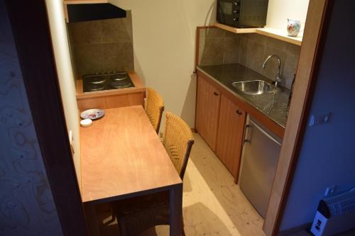 a small kitchen with a wooden table and a sink at Maison Zélandaise in Koudekerke