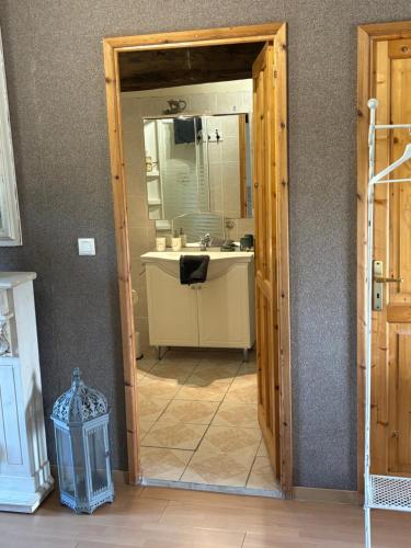 a bathroom with a sink and a mirror at La Grange aux coccinelles in Saint-Martin-des-Fontaines