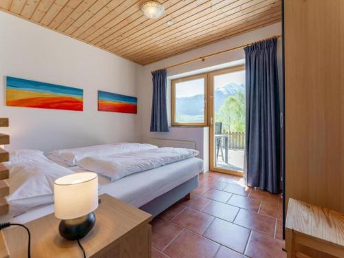 a bedroom with a bed and a table and a window at Chapter Two in Niedernsill