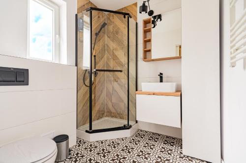 a bathroom with a shower with a tile floor at Cute house in Kretowiny