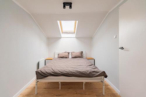 a bed in a white room with a window at Cute house in Kretowiny