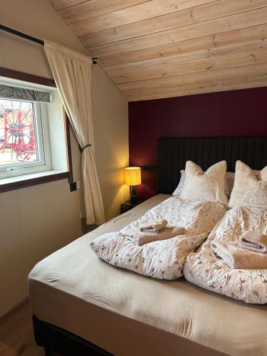 a bedroom with a large bed with a window at Hoofprints Farm stay in Fludir