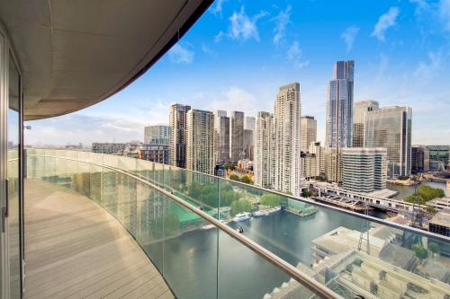 a view of the city from the balcony of a building at London Canary Wharf Luxury Stay in London