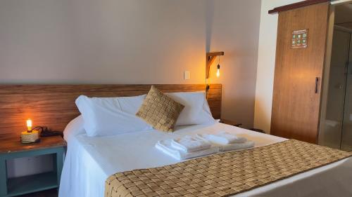 a bedroom with a bed with towels on it at Hotel Porto Di Mare in Ubatuba