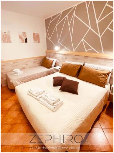 a bedroom with a large bed and a couch at Zephiro Guest House in La Maddalena