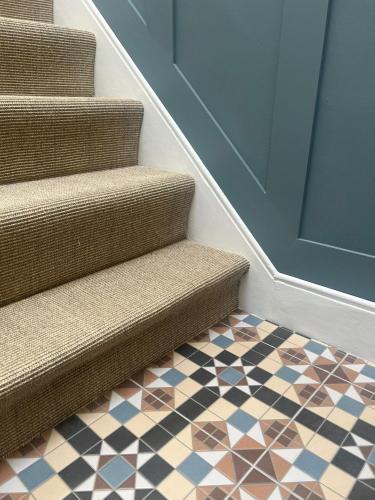 a set of stairs with a door and a tile floor at Glenesk No 1 , Woodhall Spa in Woodhall Spa