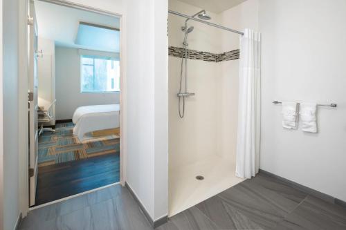 a bathroom with a shower and a bedroom at EVEN Hotel Miami - Airport by IHG in Miami