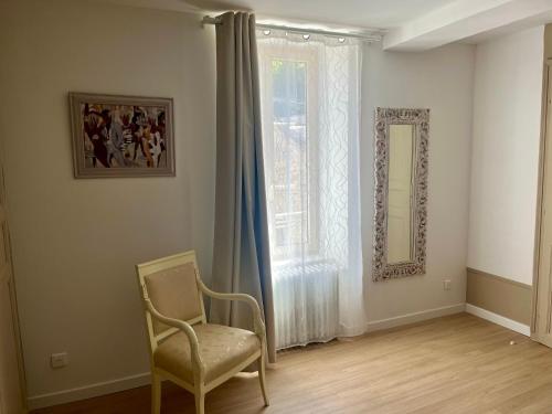 a chair in a room with a window and a mirror at Gîte Centre Chatillon 130m2 Parking prive La Maison d Hyppolite in Châtillon-sur-Seine