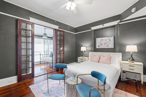 a bedroom with a white bed and blue chairs at Southern Wind Inn in St. Augustine