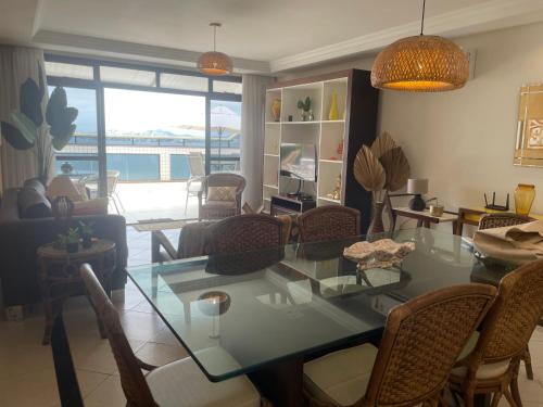 a living room with a glass table and chairs at Paraíso à vista Cobertura Linear Canto Nobre in Guarapari
