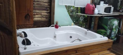 a large white bath tub in a room at Chalé Hidro Jurerê in Florianópolis
