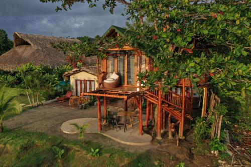 a small tree house with a table and chairs at MAKAI BEACH HOSTEL in Punta de Piedra