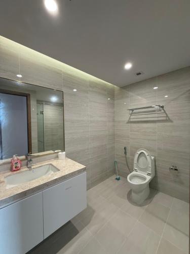a bathroom with a toilet and a sink and a mirror at BRG Premium Apartments in Hai Phong