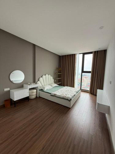 a bedroom with a bed and a desk and a window at BRG Premium Apartments in Hai Phong