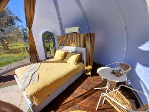 a bedroom with a bed and a table in a room at La Bulle des alpagas in Herry