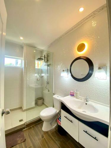 a bathroom with a toilet and a sink and a mirror at Dajon#4-Barkada Generator & starlink in General Luna