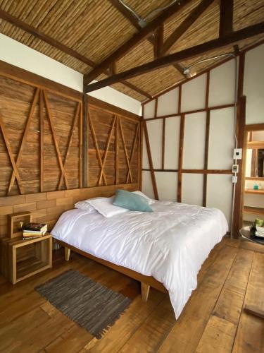 a large bed in a room with wooden ceilings at Montana Posada in Roldanillo