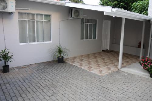 a white house with two potted plants in front of it at Casa com estacionamento no centro de Concórdia SC in Concordia