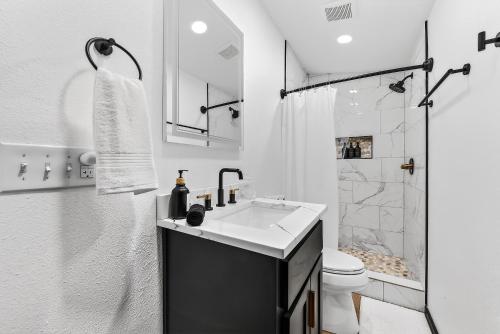 a white bathroom with a sink and a shower at Radcliffe Ride Out Modern Bella Vista Retreat- Game Room, Fire Pit, Pet Friendly - Sleeps 10 in Bella Vista