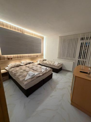 a bedroom with two beds and a large window at Teo's Guest House in Dospat