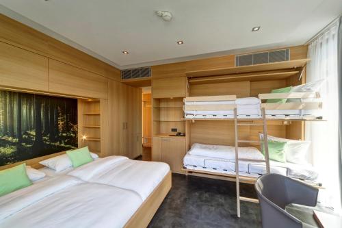 a bedroom with two bunk beds and a desk at ibis Styles Nagold-Schwarzwald in Nagold