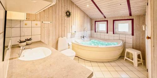 a bathroom with a tub and a toilet and a sink at VE040-Vejers-Strand-Jafdalvej-5 in Vejers Strand