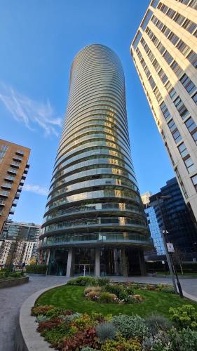 a large glass building in a city at London Canary Wharf Luxury Stay in London