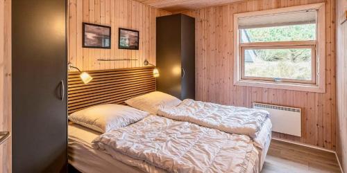 a bedroom with a bed and a window at VE125-Vejers-Strand-Aavej-19 in Vejers Strand