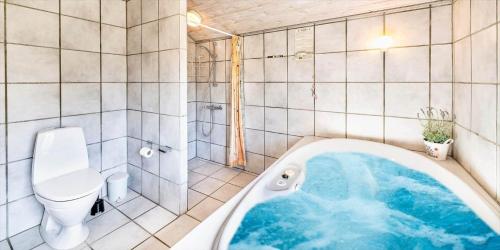 a bathroom with a bath tub and a toilet at VE047-Vejers-Strand-Jafdalvej-91 in Vejers Strand