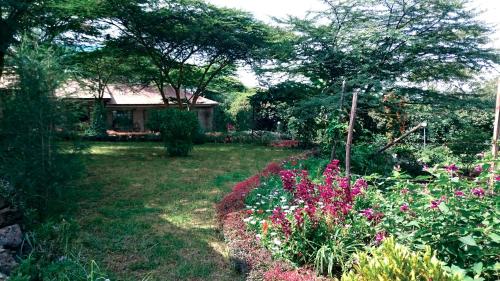 a garden with flowers and a house in the background at Osoita Lodge in Nairobi