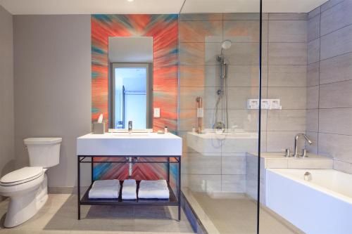 a bathroom with a sink and a tub and a toilet at Canvas Moncton, Tapestry Collection By Hilton in Moncton