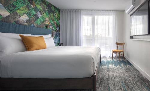 a hotel room with a bed and a window at Canvas Moncton, Tapestry Collection By Hilton in Moncton