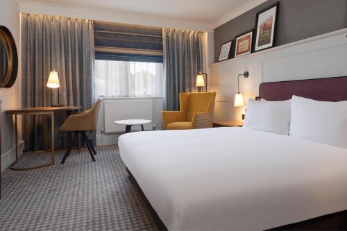 a hotel room with a large white bed and a desk at DoubleTree by Hilton Stoke-on-Trent, United Kingdom in Stoke on Trent