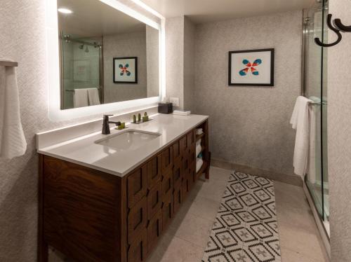 a bathroom with a sink and a mirror at Estancia del Norte San Antonio, A Tapestry Hotel by Hilton in San Antonio