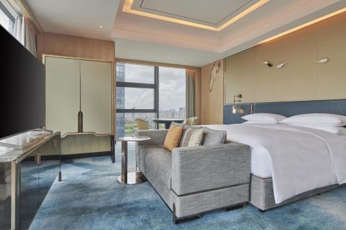 a hotel room with a bed and a couch at Hilton Yancheng in Yancheng