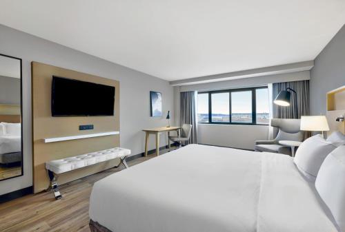 a hotel room with a large bed and a flat screen tv at DoubleTree by Hilton Davenport in Davenport
