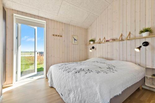 a bedroom with a bed and a large window at 8529-Grenaa-Strandsletten-61 in Grenå