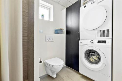 a bathroom with a washing machine and a toilet at 8529-Grenaa-Strandsletten-61 in Grenå