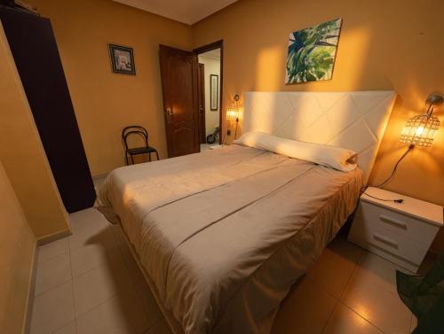 a bedroom with a large bed and a table and lamp at Paseo del mar in Melilla