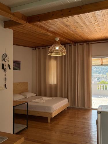 a bedroom with a bed and a chandelier at Sea Breeze Rooms in Himare