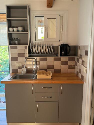 a kitchen with a sink and a counter top at Sea Breeze Rooms in Himare