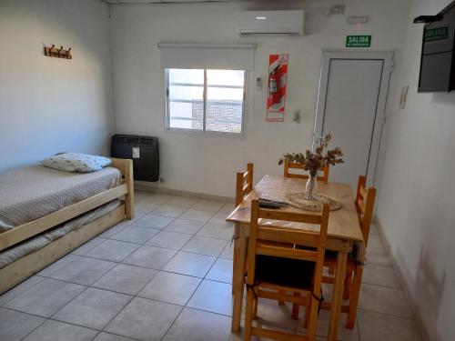a room with a table and a bed and a table and chairs at Departamentos TUNQUELEN in Colorado River