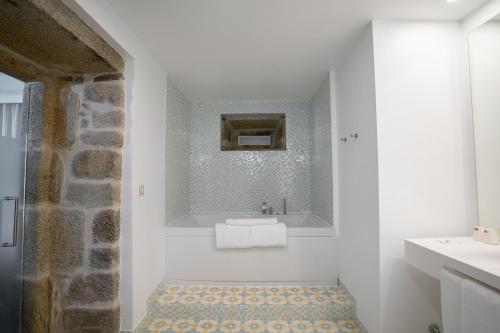 a white bathroom with a sink and a mirror at Convento do Seixo Boutique Hotel & Spa in Fundão