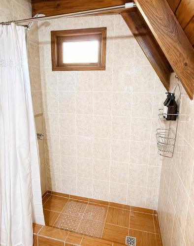 a bathroom with a shower with a shower curtain at Cabañas Chucao 2 in San Martín de los Andes